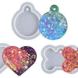 Puede incluir: Cuatro moldes de silicona para hacer joyas de resina. Los moldes tienen forma de círculo, corazón y hueso. Los moldes se muestran con piezas de resina terminadas en su interior.