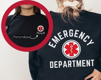 May include: Black sweatshirt with white text that reads "EMERGENCY DEPARTMENT" and a red medical symbol with a snake. The sweatshirt has a small pocket on the left chest with the text "Stacey, RN" in white.