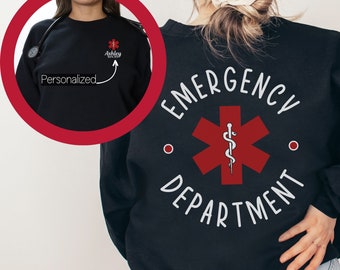 May include: Black sweatshirt with a red star of life and the text "EMERGENCY DEPARTMENT" in white. The star of life has a snake and staff symbol inside. The sweatshirt has a small pocket on the left chest with a red star of life and the text "Ashley RN" in white.