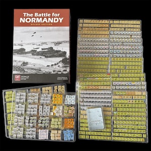 Könnte beinhalten: Brettspiel The Battle for Normandy Deluxe Edition. Die Box ist rot und schwarz mit einem Schwarz-Weiß-Bild von Schiffen. Das Set enthält Spielsteine in transparenten Kunststoffschalen und eine Karte mit der Aufschrift "Interdiction 1".