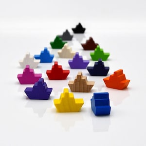Puede incluir: Un conjunto de 15 barcos de madera coloridos, cada uno con un color diferente, incluyendo rojo, azul, verde, amarillo, naranja, rosa, morado, blanco y marrón. Los barcos están dispuestos en una fila, con el barco más grande en la parte posterior y el barco más pequeño en la parte delantera.
