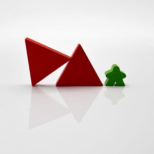 May include: Two red wooden triangles, one leaning against the other, and a green wooden star-shaped game piece.