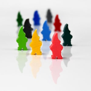 Puede incluir: Un conjunto de figuras de gnomos de madera de colores, incluyendo verde, amarillo y rojo. Los gnomos están de pie, con un fondo blanco y reflejos. Ideales para juegos de mesa.