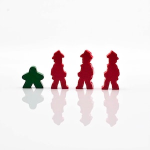 May include: Three red wooden game pieces shaped like people standing in a row. A green wooden game piece shaped like a star is in front of the red pieces.