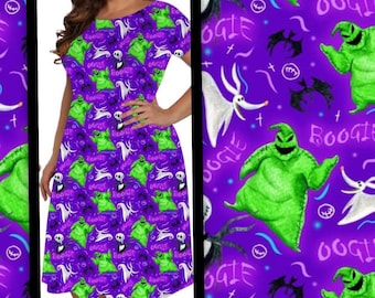 May include: A purple dress featuring a pattern of green Oogie Boogie characters, white Zero ghosts, and skull figures. The dress has a scoop neckline and short sleeves. The word "Boogie" is also visible in the design.