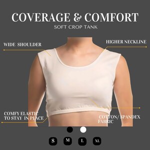 May include: White crop tank top with a higher neckline and wide shoulder straps. The tank top has a comfy elastic band at the bottom to stay in place. The fabric is a cotton spandex blend. The tank top is available in sizes S, M, L, and XL.