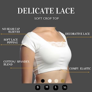 May include: White crop top with delicate lace trim around the neckline. The top has short sleeves and a comfortable elastic waistband. The text "DELICATE LACE" and "SOFT CROP TOP" is displayed above the image. The text "NO SEAM CAP SLEEVES", "SOFT LACE PIPPING", "COTTON/SPANDEX BLEND", "DECORATIVE LACE", and "COMFY ELASTIC" is displayed around the image. The sizes S, M, L, and XL are displayed below the image.