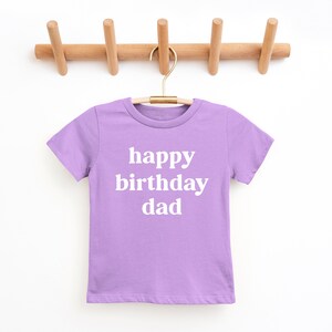 May include: A lavender t-shirt with the text "happy birthday dad" in white.