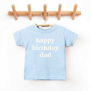 May include: A light blue t-shirt with the text "happy birthday dad" in white.