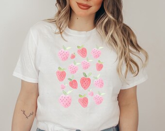 Puede incluir: Camiseta blanca con un patrón de fresas rosas y verdes.