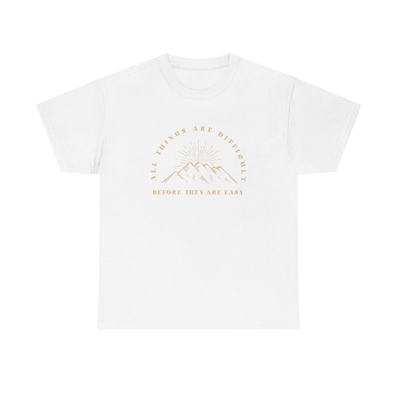 May include: White t-shirt with a graphic of mountains and the text "All things are difficult before they are easy."