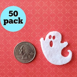 May include: A pack of 50 white felt ghost shapes, each about the size of a US quarter. The ghosts have two black eyes and a black mouth.