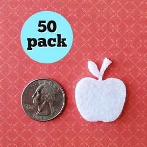 May include: A pack of 50 white felt apple shapes. The apples are about the size of a US quarter.