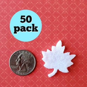 May include: A pack of 50 white felt maple leaves. The leaves are about the size of a US quarter.