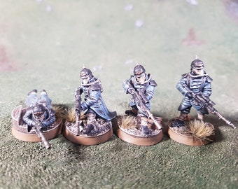 May include: Four miniature figures of soldiers wearing blue uniforms and black helmets, holding rifles. The figures are standing on round bases with brown paint and brown grass-like material.