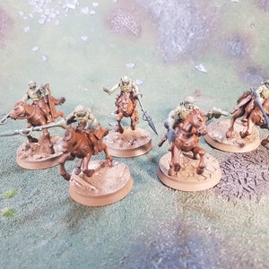May include: Five miniature figures of mounted soldiers, painted in a muted green and brown color scheme, are posed on circular bases. The figures are holding spears and swords, and the horses are in a running pose.