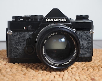 Olympus OM-1n analog 35mm film camera in excellent condition. Cleaned, lubed and adjusted, film tested and guaranteed!