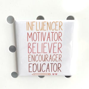May include: A white square button with the words "INFLUENCER, MOTIVATOR, BELIEVER, ENCOURAGER, EDUCATOR" in a gradient of orange and red lettering. A pencil and two hearts are at the bottom. The button is set against a white background with circular cutouts.