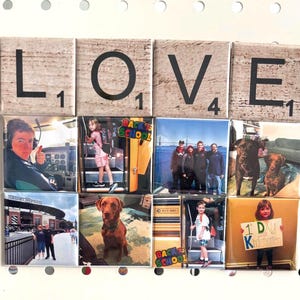 May include: A collection of square magnets arranged on a white surface. The magnets spell "LOVE" with Scrabble tiles and feature various photographs, including images of people, dogs, and the text "BACK TO SCHOOL" and "1 DU K".