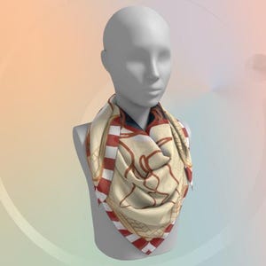 K&ouml;nnte beinhalten: Ein quadratisches Tuch mit cremefarbenem Hintergrund und einem sich wiederholenden Muster aus rot-wei&szlig;en Streifen und braunen dekorativen Elementen. Das Tuch ist um den Hals einer Schaufensterpuppe drapiert und zeigt sein Design und seine Textur. Ca. 90 cm x 90 cm.