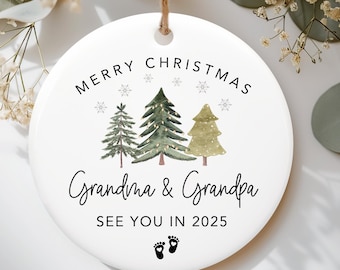Może przedstawiać: Okrągła, biała ceramiczna ozdoba świąteczna z napisem "Merry Christmas Grandma & Grandpa See You in 2025" oraz ilustracjami trzech choinek i płatków śniegu. Zawiera sznurek jutowy do zawieszenia.