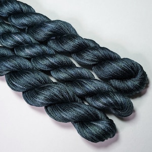 May include: Three skeins of dark teal embroidery floss, twisted together.