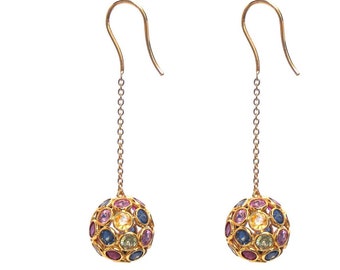 May include: Gold dangle earrings with a round, multi-colored gemstone cluster. The gemstones are set in a gold sphere and are a mix of pink, blue, green, and yellow.