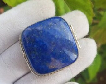 May include: A square-shaped lapis lazuli gemstone pendant with a silver setting. The gemstone is a deep blue color with a slight shimmer.