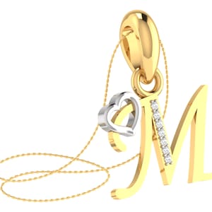 May include: A gold pendant necklace with a cursive letter "M" charm and a small heart charm. The heart charm has a white gold finish and is set with small diamonds.