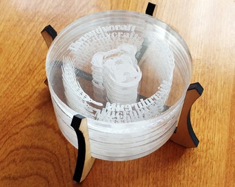 Può includere: Un sottobicchiere in acrilico trasparente a strati con un design 3D e testo. Il sottobicchiere poggia su un supporto in legno con dettagli neri. Il testo sul sottobicchiere recita "midworycraft".