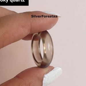 May include: A smoky quartz ring with a smooth, translucent finish. The ring is a light brown colour and has a simple, elegant design.
