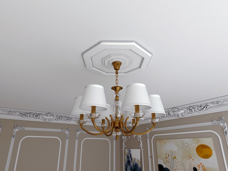 K&ouml;nnte beinhalten: Ein goldener Kronleuchter mit wei&szlig;en Lampenschirmen h&auml;ngt an einer wei&szlig;en Decke mit dekorativen Leisten. Der Kronleuchter hat ein Kristall-Mittelst&uuml;ck und eine Kette.