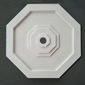 Peut inclure: Médaillon de plafond octogonal blanc avec des octogones concentriques, créant un effet de superposition.