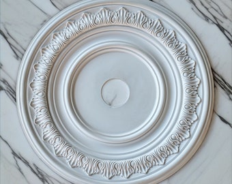 Könnte beinhalten: Weiße Deckenrosette mit einem dekorativen, verzierten Design. Die Rosette ist rund mit einer erhabenen Mitte und einem detaillierten Rand.