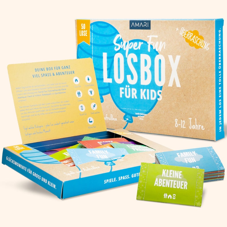 Detailansicht der AMARI Kinder-Losbox auf einem Tisch mit ausgebreiteten Losen – inspiriert zu kreativen Spielstunden.