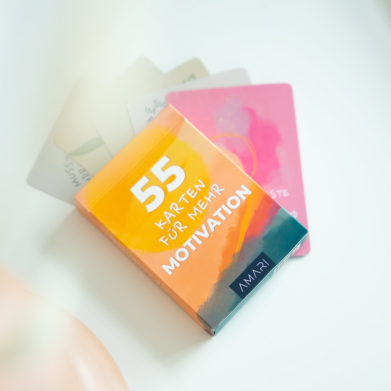 Verpackung der AMARI Achtsamkeitskarten liegt auf einem Tisch – perfekt gestaltet, um Freude und Motivation täglich zu inspirieren.