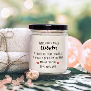 May include: A white candle jar with a black lid and a label that reads "Thanks for being my coworker. If I had a different coworker, I would punch her in the face and go find you. Love, your name."