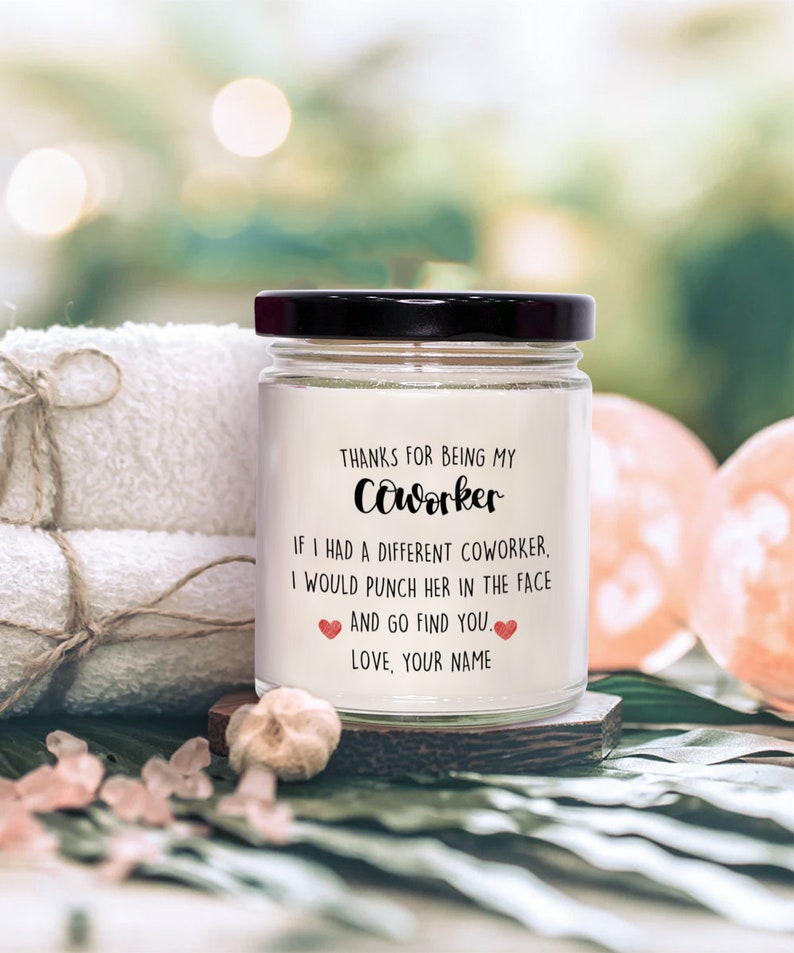 May include: A white candle jar with a black lid and a label that reads "Thanks for being my coworker. If I had a different coworker, I would punch her in the face and go find you. Love, your name."
