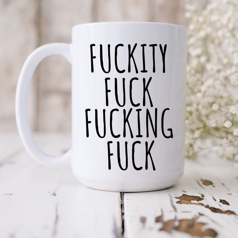 May include: White ceramic coffee mug with black text that reads "F*ckity F*ck F*cking F*ck".