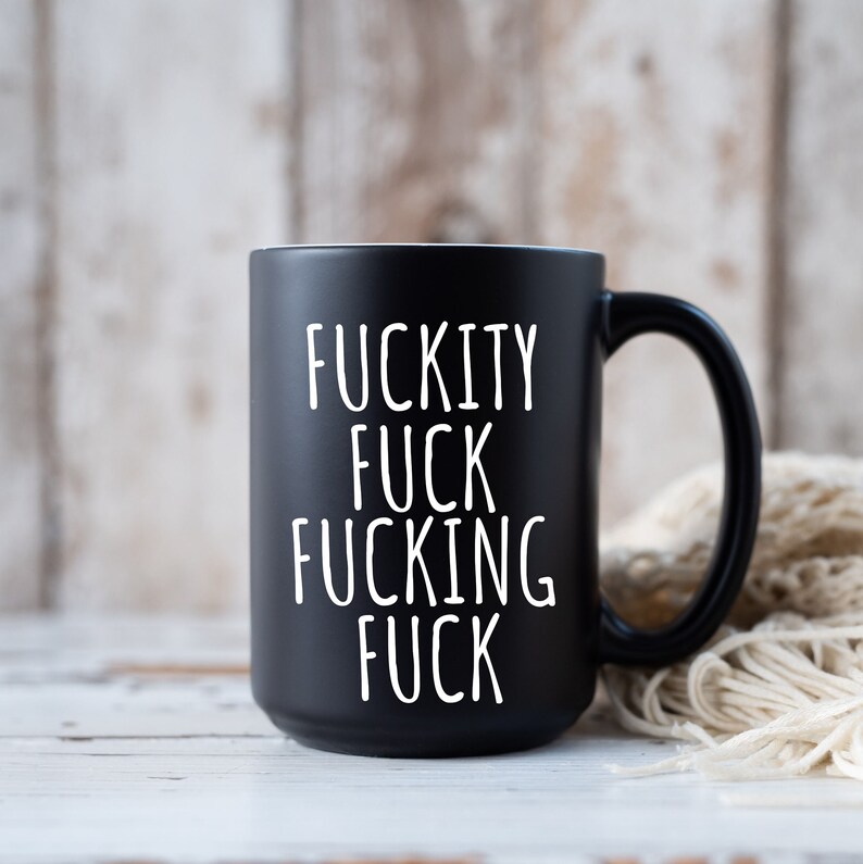May include: Black coffee mug with white text that reads "F*ckity F*ck F*cking F*ck".