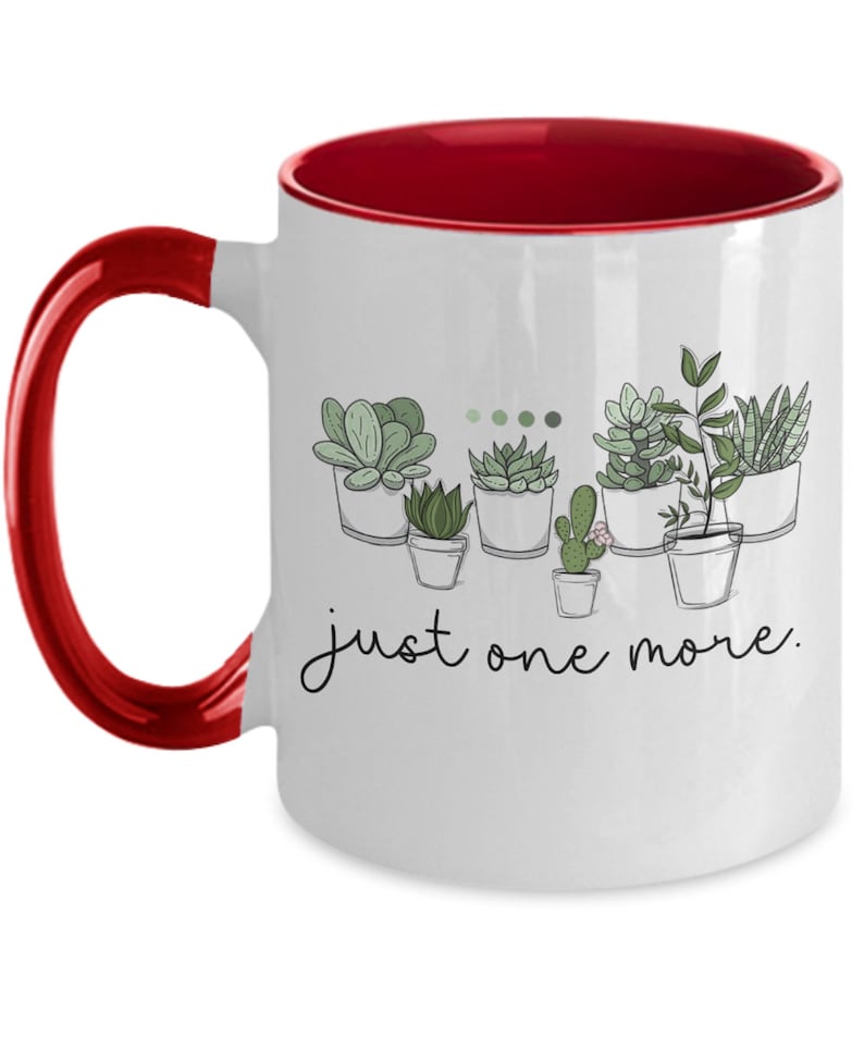 May include: White ceramic coffee mug with a red rim and handle. The mug features a line drawing of potted succulents with the text "just one more."