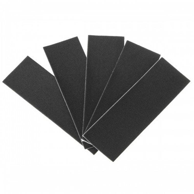 May include: A fan of five black rectangular hook and loop fastener strips, arranged on a white background. The strips are made of a textured material and have a white border. The strips are fanned out, with the ends of the strips pointing towards the viewer.