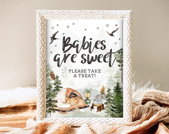 May include: A white framed sign with a watercolor illustration of a forest scene with a tent, a campfire, and birds. The text on the sign reads "Babies are sweet. Please take a treat!"