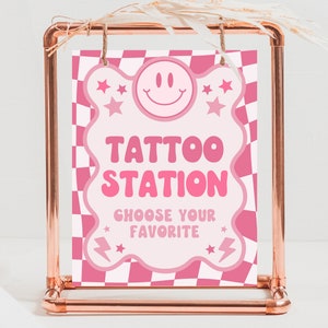 Peut inclure: Un panneau à damiers rose et blanc avec une forme de nuage rose. Le panneau indique "Tattoo Station" et "Choisissez votre préféré".