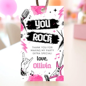May include: Pink and black thank you tag with a rock and roll theme. It says "You Rock" with a pink electric guitar and a microphone. The text "Thank you for making my party extra special! Love, Olivia" is also included.