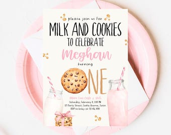 Puede incluir: Una tarjeta de invitación blanca con acentos rosados y dorados. La tarjeta presenta una ilustración de acuarela de una galleta con chispas de chocolate, un vaso de leche y una pajita. El texto en la tarjeta dice "Por favor, únase a nosotros para tomar leche y galletas para celebrar que Meghan cumple un año".