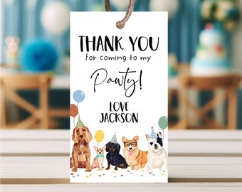 May include: Thank you for coming to my Pawty!  A white thank you card with a black and white paw print design. The card features a group of dogs wearing party hats and surrounded by colorful balloons. The text "Love Jackson" is printed below the paw print.