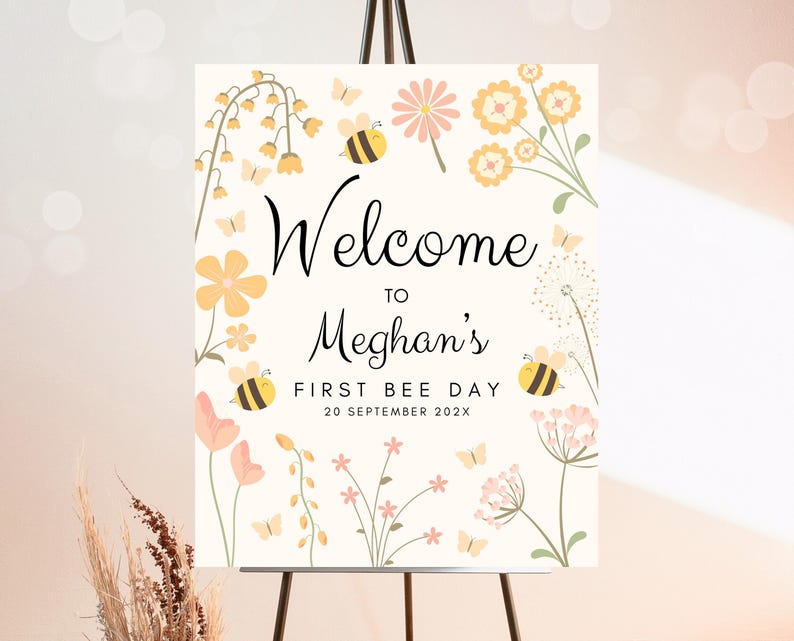 Op de afbeelding: Welkom op Meghans eerste bijendag, een wit bord met gele en roze bloemen, bijen en de tekst "Welkom op Meghans eerste bijendag 20 september 202X"