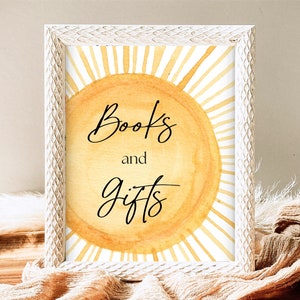 Könnte beinhalten: Ein weißer Rahmen mit einem Aquarellbild einer Sonne mit dem Text "Books and Gifts" in Schwarz.