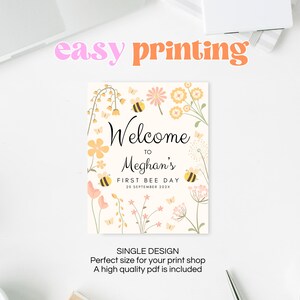 Op de afbeelding: Een printbaar welkomsbord met een bloemenontwerp en bijen. Het bord zegt "Welkom bij Meghan's First Bee Day 20 september 202X".